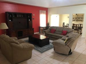 a living room with two couches and a flat screen tv at Agapantha Cottage in Mandeville