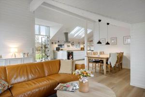 a living room with a brown leather couch and a table at 30156-Odder-Chr-Christensensvej-4 in Beder
