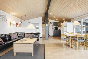 uma sala de estar com um sofá preto e uma mesa em 30462-Odder-Kirkeager-7 em Odder