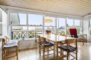 uma sala de jantar com mesa, cadeiras e janelas em 30462-Odder-Kirkeager-7 em Odder mais 18 fotografias