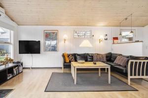 uma sala de estar com um sofá e uma mesa em 30462-Odder-Kirkeager-7 em Odder