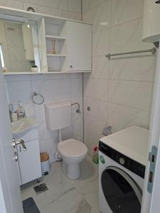 a small bathroom with a toilet and a washing machine at Apartman Borik in Banja Luka +6 photos