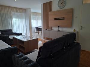 a living room with couches and a clock on the wall at Apartman Borik in Banja Luka
