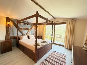a bedroom with a canopy bed and a balcony at Manzara Bungalov in Fethiye
