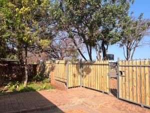 a wooden fence with a gate in a yard at 39 Shone GH in Postmasburg +19 photos