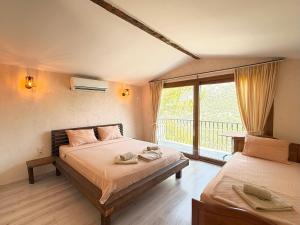 a bedroom with two beds and a balcony at Manzara Bungalov in Fethiye +81 photos