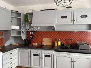 a kitchen with white cabinets and black counter tops at Le Ranch - chambres d'hôtes - proche centre ville in Reims +5 photos