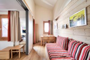 una sala de estar con un sofá y una mesa en Résidence Plagne Lauze - maeva Home - Studio 4 personnes avec parking - Sélection MAE-2893, en Plagne 1800