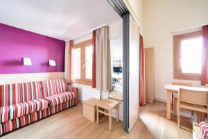 Una sala de estar con un sofá y un espejo. en Résidence Plagne Lauze - maeva Home - Studio 4 personnes avec parking - Sélection MAE-2893, en Plagne 1800 39 fotos más