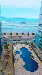 een uitzicht op het strand en de oceaan vanuit een gebouw bij Ape Condomínio Club - pé na areia in Mongaguá