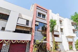 an apartment building with white and red at Hotel O Sachin Residency in Nashik