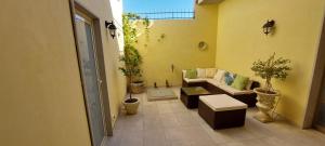 sala de estar con sofá y macetas en Casa Bernini, en Avola