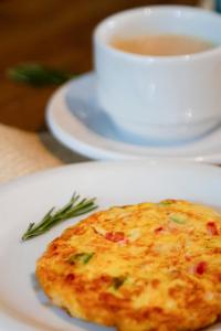 a white plate with a piece of food and a cup of tea at Hotel Areias Belas in Maragogi