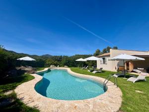 a pool with chairs and umbrellas in a yard at Luna&Limoni Country in Muravera