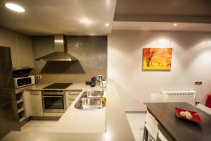 una cocina con encimeras blancas y una pintura en la pared en WinTuWin Apartments, en Rialp