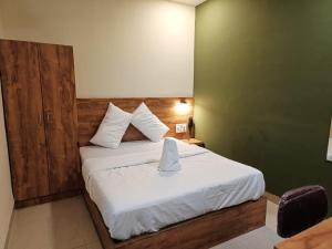 una camera da letto con un letto e un tovagliolo sopra di Glitz Hotels-Mumbai Inn-Saki Naka Junction a Mumbai