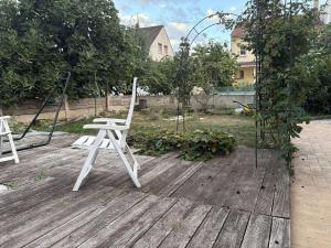 two white chairs sitting on top of a wooden deck at Le Ranch - chambres d'hôtes - proche centre ville in Reims