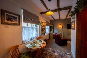 a living room with a table and a chair at Nettle Cottage in Heysham