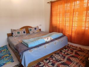 een groot bed in een kamer met een tapijt bij Labrang Home Stay in Stak