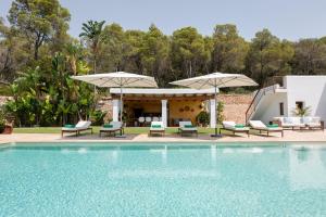a swimming pool with chairs and umbrellas next to a house at New! Villa Llosas de Dalt in Sant Carles de Peralta +30 photos