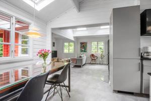 een keuken en woonkamer met een tafel en stoelen bij 30353-Odder-Lyngmarksvej-17 in Odder +30 foto's