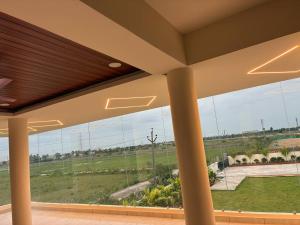 a large window in a building with a view of a field at V guesthouse staycation in Bāpatla
