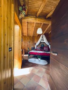 1 dormitorio con cama roja en el techo de madera en Baita RosiCin, en Paisco