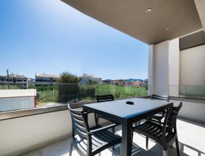un tavolo e sedie su un balcone con una grande finestra di Euphoria Blue Lefkada a Città di Lefkada