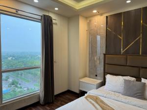 Un dormitorio con una cama y una ventana grande. en 1 bhk at elysium downtown, en Islamabad