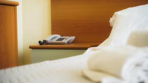 a phone sitting on a shelf next to a bed at Hotel Atlantic in Giulianova +94 photos