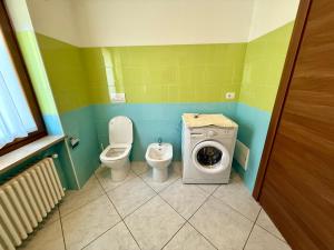 a bathroom with a toilet and a washing machine at Villa Monti in Courmayeur +34 photos