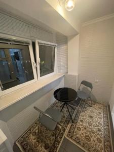 キシナウにあるModern Apartament Centru Rîșcaniの椅子2脚とテーブル1台と窓のある部屋 +6枚の写真