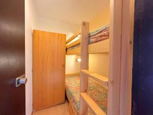 a bedroom with a bunk bed with a ladder to a bunk bed at Studio cabine rénové pour 4 pers, balcon, animaux admis - FR-1-452-55 in Les Menuires