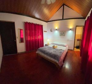 a bedroom with a large bed with red curtains at Hostal La India in Valle de Anton +54 photos