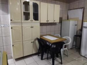 a kitchen with a table and some white cabinets at Casa completa para 4 pessoas in Itu +8 photos