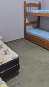 a bedroom with two bunk beds and a tile floor at Casa completa para 4 pessoas in Itu