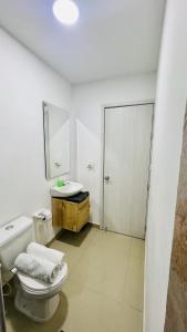 Un baño con inodoro, lavabo y espejo. en 304 studio apartment in El Peñon, en Cali 13 fotos más