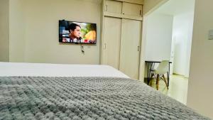Un dormitorio con una cama y un televisor de pantalla plana. en 304 studio apartment in El Peñon, en Cali