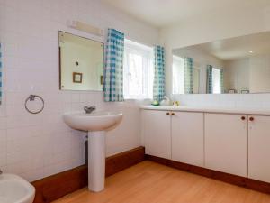 Un baño blanco con lavabo y espejo. en Rosewin Farmhouse, en Saint Minver 27 fotos más