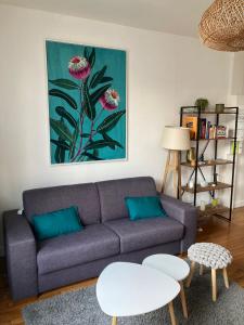 een woonkamer met een paarse bank en 2 tafels bij Hyper centre lumineux avec balcon in Tours