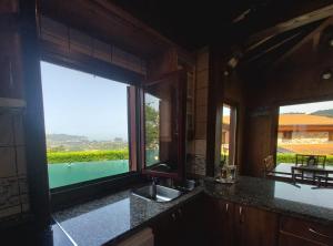 a kitchen with a sink and a large window at Olivar 51 in Villaviciosa