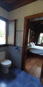 1 dormitorio con 1 cama y baño con aseo. en Olivar 51, en Villaviciosa