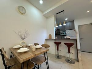 a kitchen and dining room with a wooden table and chairs at KL ,2BR 2Bath Condo ,Razak city ,TV box&Pool in Kuala Lumpur