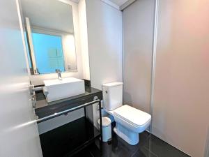 a bathroom with a white toilet and a sink at Artower de 3 dormitorios in Punta del Este