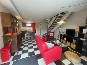 a living room with red chairs and a checkered floor at Apartamentos El Hospital de Villahormes in Villahormes