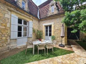 a table and chairs in front of a house at La Chartreuse Carmille in Domme
