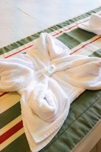 a white shirt laying on top of a bed at POUSADA OHANA PARATY in Paraty +29 photos