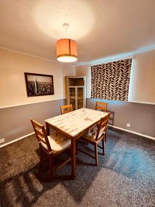 a dining room with a wooden table and chairs at Comfortable Two Bedroom Home DL5 with Garden Parking and Free WiFi  +5 photos