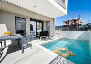 un patio esterno con piscina, tavolo e sedie di Euphoria Blue Lefkada a Città di Lefkada