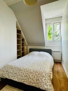 een slaapkamer met een bed en een raam bij Appartement calme et spacieux, tout équipé in Saint-Quentin